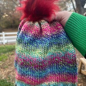 Hand knit beanie featuring a faux fur pom pom